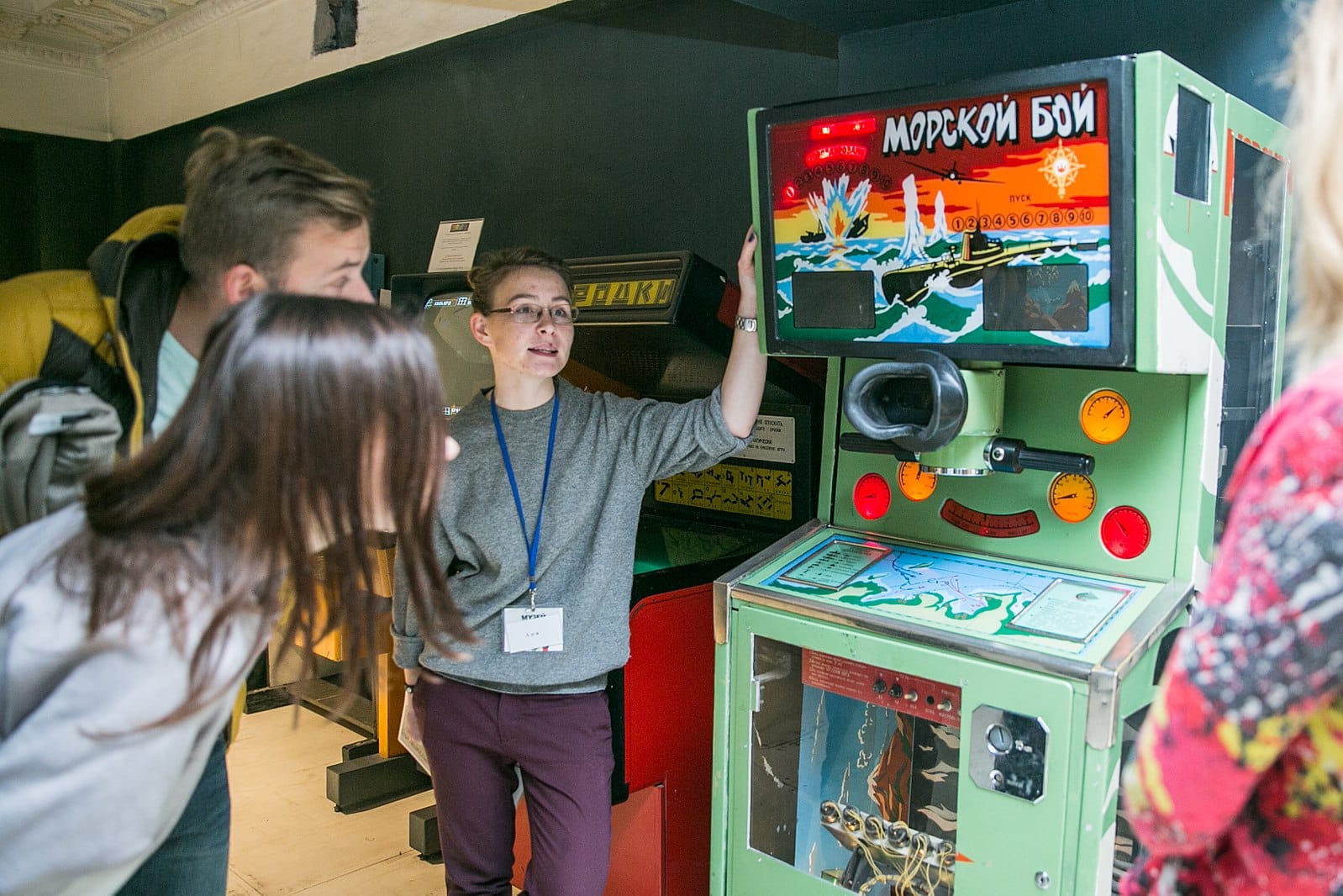 Посетители Музея советских игровых автоматов в Москве рядом с автоматом «Морской бой»
