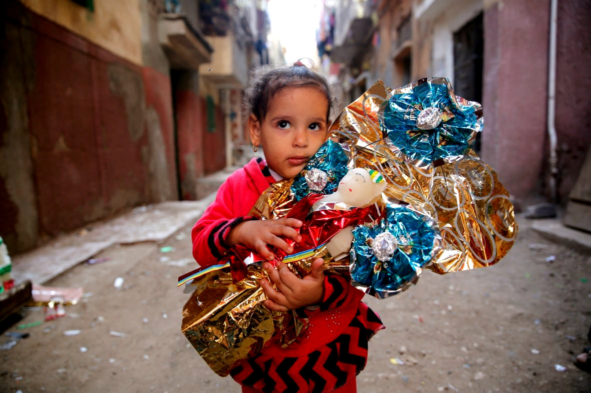 Девочка обнимает Аросета Эль Мулида, традиционные сахарные конфеты в форме кукол в день рождения пророка Мухаммеда